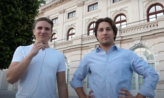 Zwei junge Männer vor der Fassade eines historischen Theatergebäudes