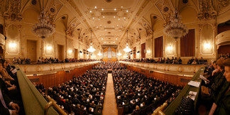 Prunkvoller Konzertsaal vom Musikverein Graz mit vollem Publikum, Blick auf Bühne und Orgel.