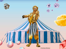 Farbenfrohes Zirkusmotiv mit Statue von Johann Strauss vor blau-weißem Zelt und fantasievollen Elementen