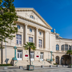 Klassizistische Fassade des Stadttheaters Baden mit Palmen am Vorplatz