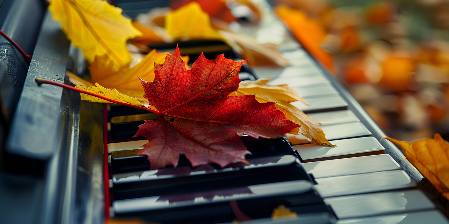 Bunte Herbstblätter liegen auf den Tasten eines Klaviers im Freien.
